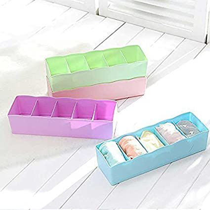 Three colorful plastic storage boxes on a white wooden floor.