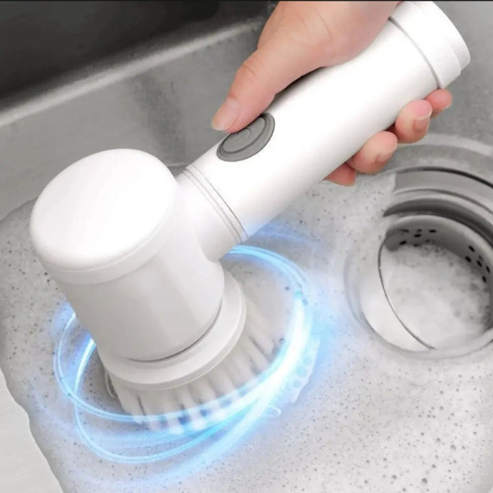Hand holding a white electric scrubber with blue light in a sink