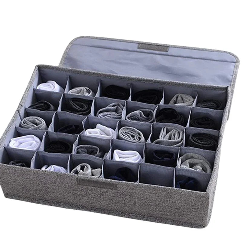 Gray sock organizer with multiple compartments filled with socks on a white background