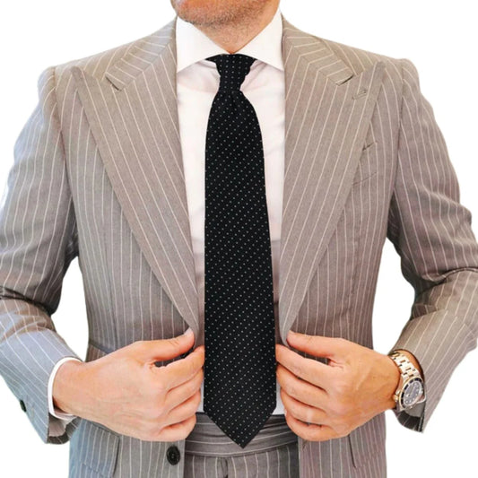 Man wearing a gray pinstripe suit with a black tie on a white background