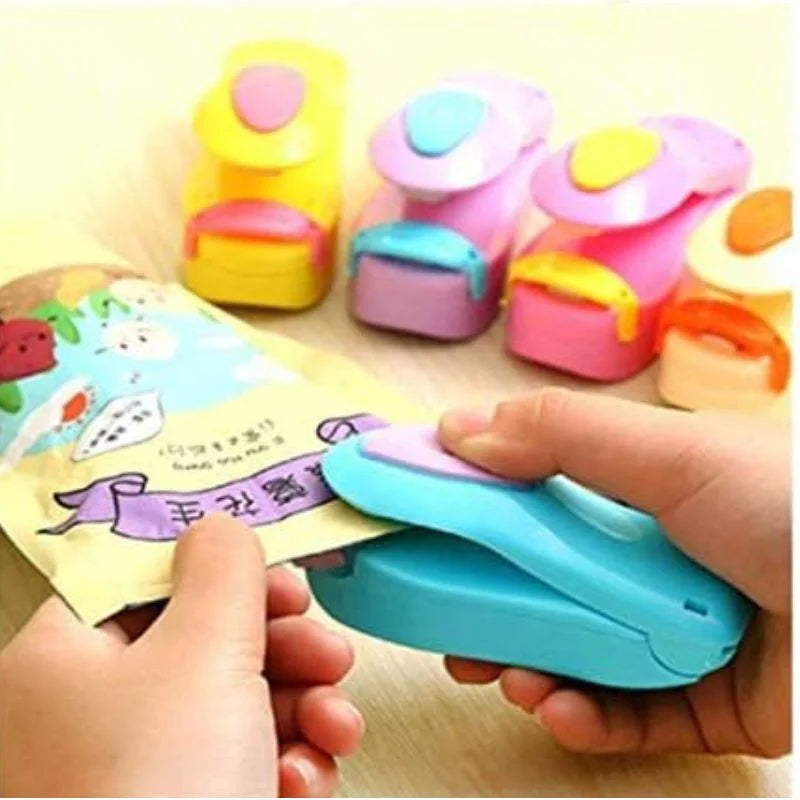 Colorful paper puncher with a hand using it on a wooden surface