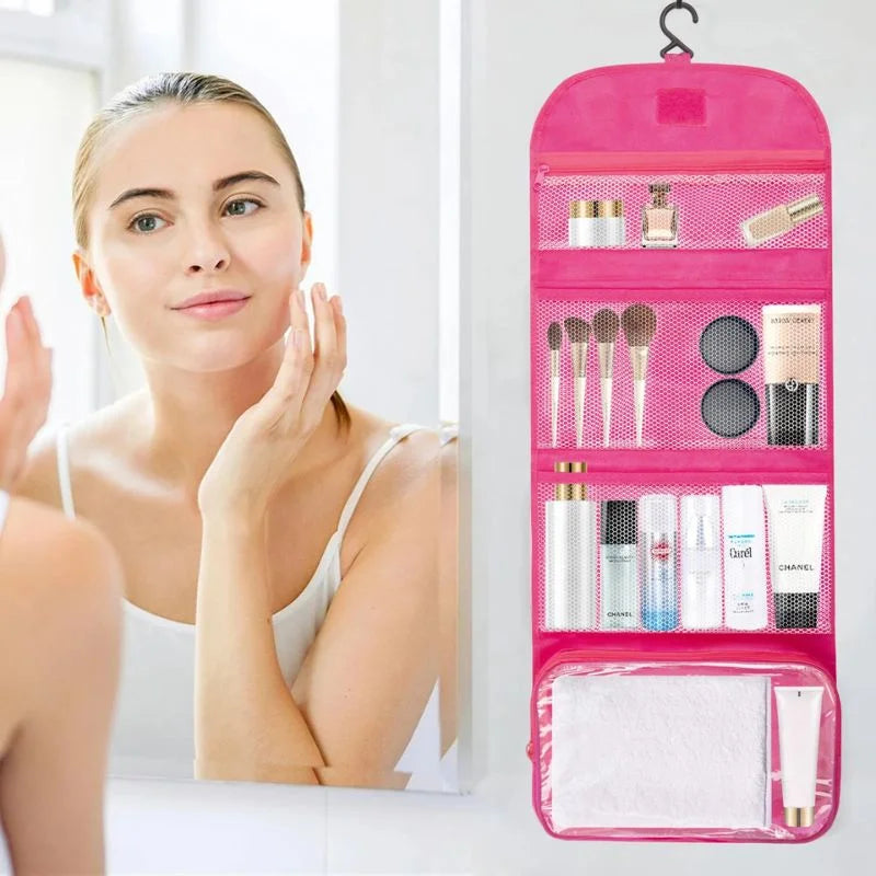 Woman applying makeup with a pink hanging cosmetic bag filled with products on a white background