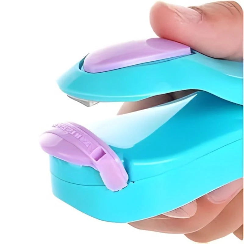 Turquoise and purple hole puncher held by a hand on a white background