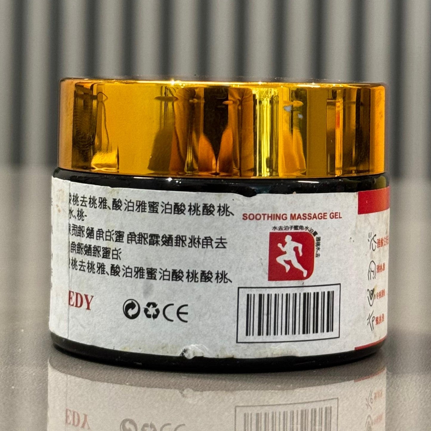 weedy soothing| Relief from Muscle Tension | 100gJar of soothing massage gel with a yellow lid on a reflective surface